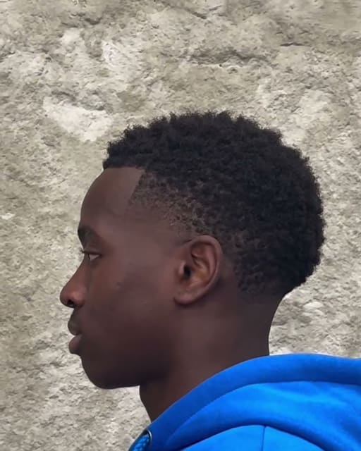 Skin fade με καθαρή γραμμή, προφίλ στον τσιμεντένιο τοίχο